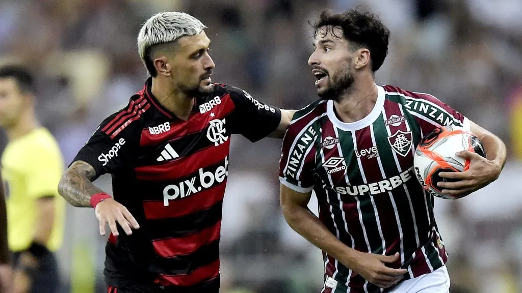 Martinelli, jogador do Fluminense disputa lance com Arrascaeta,  jogador do Flamengo, durante partida pelo campeonato Carioca 2025. Foto: Alexandre Loureiro/AGIF