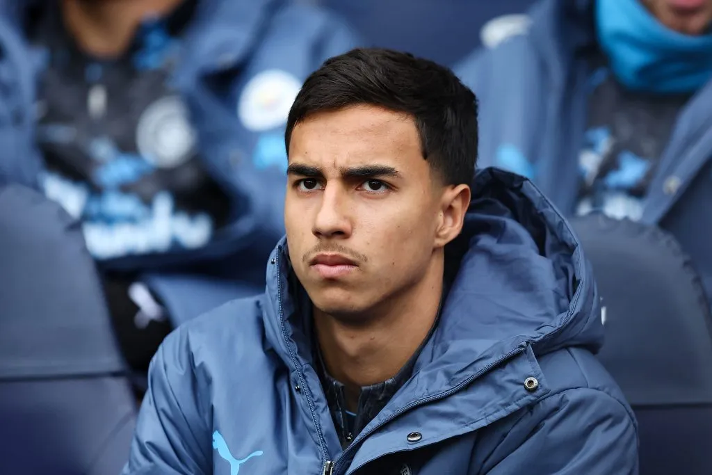 MANCHESTER, ENGLAND – MARCH 15: Vitor Reis of Manchester City looks on from the substitutes bench during the Premier League match between Manchester City FC and Brighton &amp; Hove Albion FC at Etihad Stadium on March 15, 2025 in Manchester, England. (Photo by Matt McNulty/Getty Images)