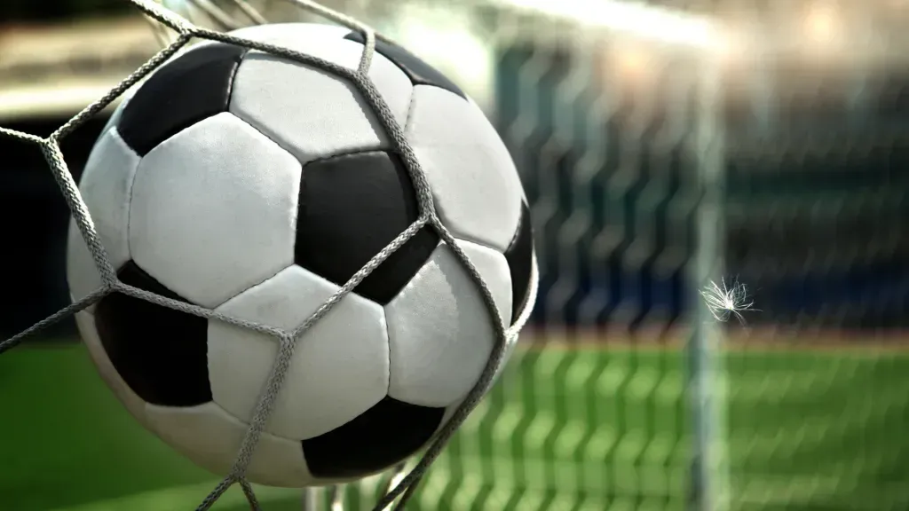 Grande plano de bola de futebol contra rede da baliza