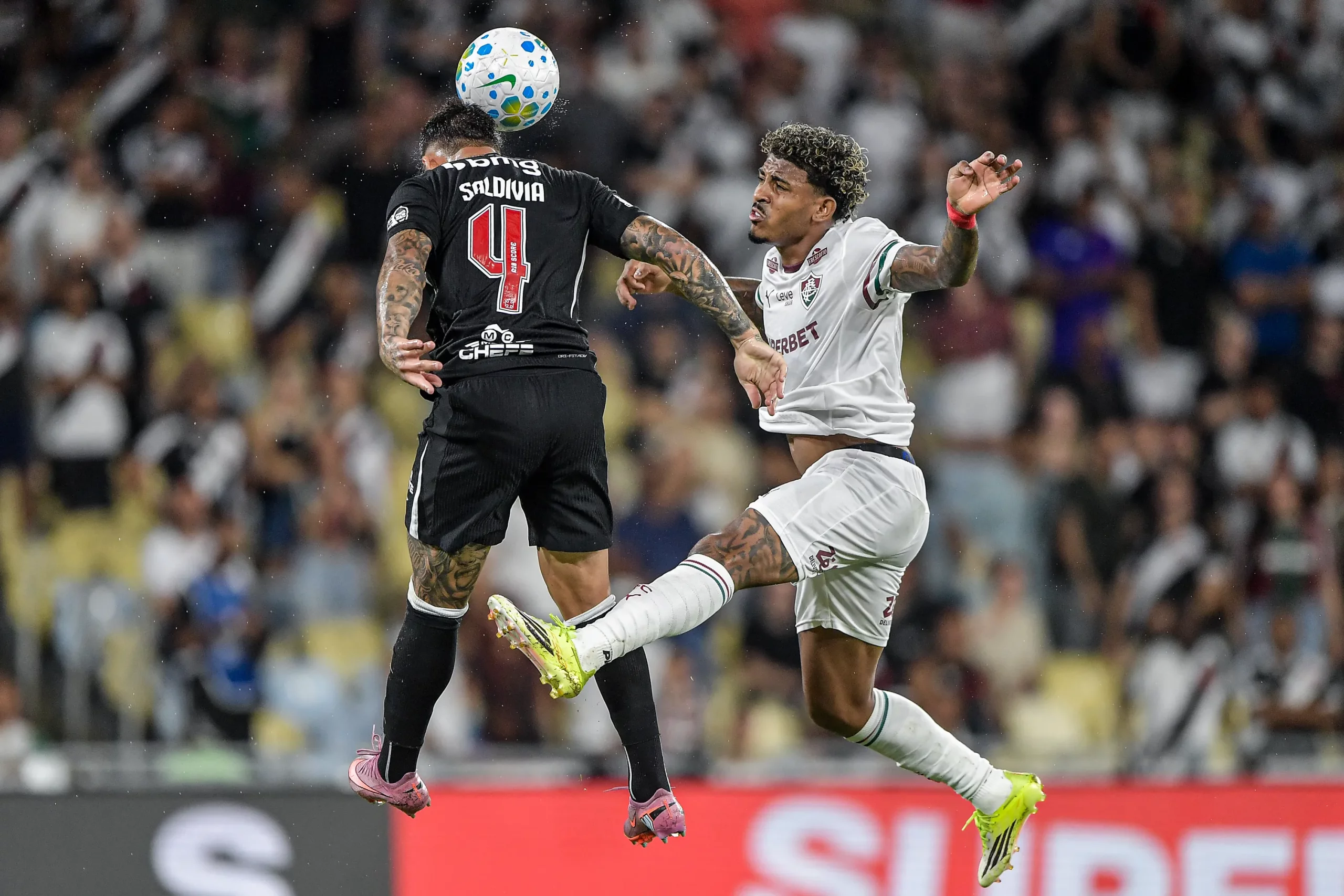Saldivia jogador do Vasco disputa lance com John Kennedy jogador do Fluminense durante partida no estadio Maracana pelo campeonato Brasileiro A 2026. Foto: Thiago Ribeiro/AGIF