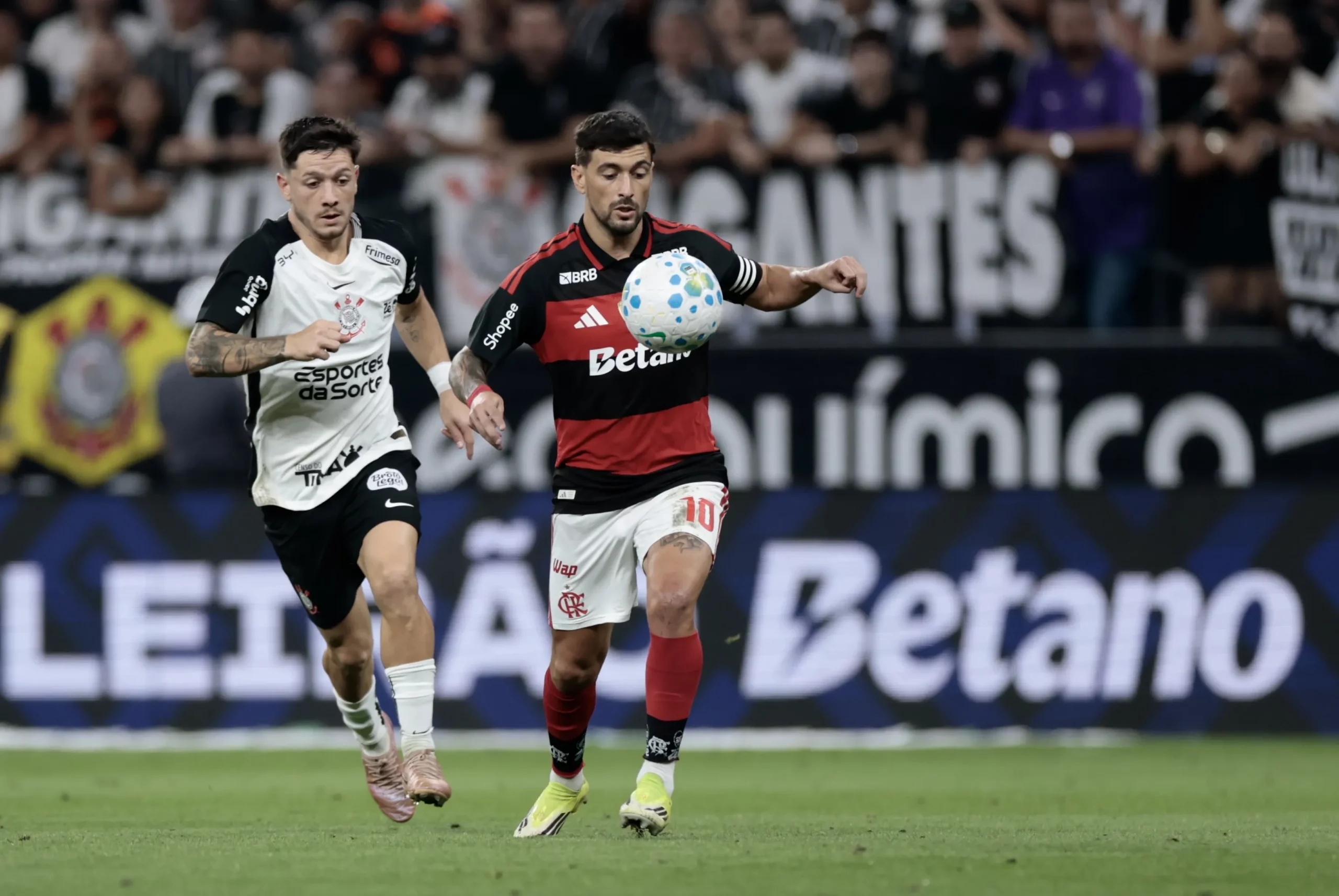Garro jogador do Corinthians disputa lance com Arrascaeta jogador do Flamengo durante partida no estadio Arena Corinthians pelo campeonato Brasileiro A 2026. Foto: Marcello Zambrana/AGIF