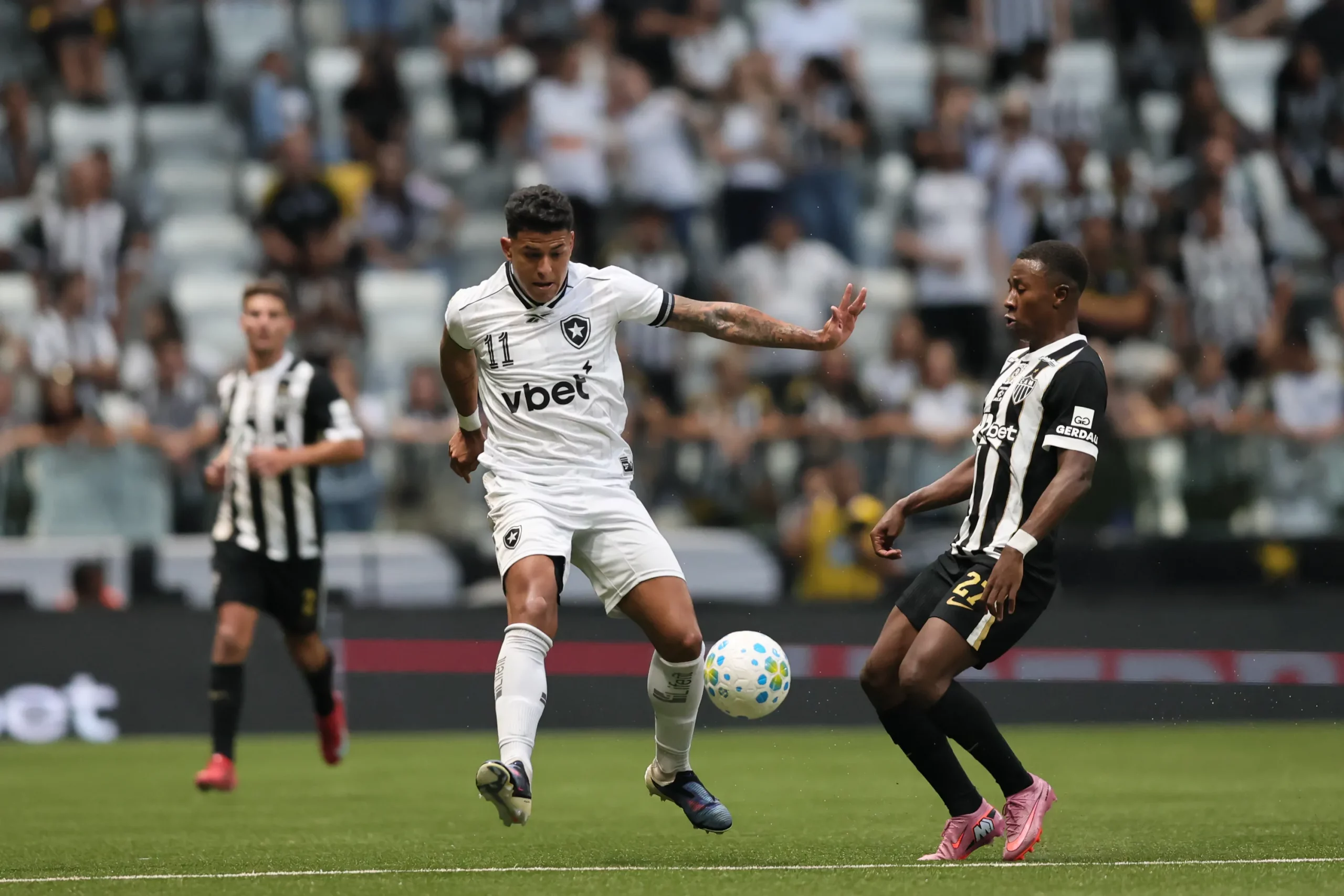 MG – BELO HORIZONTE – 10/05/2026 – BRASILEIRO A 2026, ATLETICO-MG X BOTAFOGO – Alan Minda jogador do Atletico-MG disputa lance com Matheus Martins jogador do Botafogo durante partida no estadio Arena MRV pelo campeonato Brasileiro A 2026. Foto: Gilson Lobo/AGIF