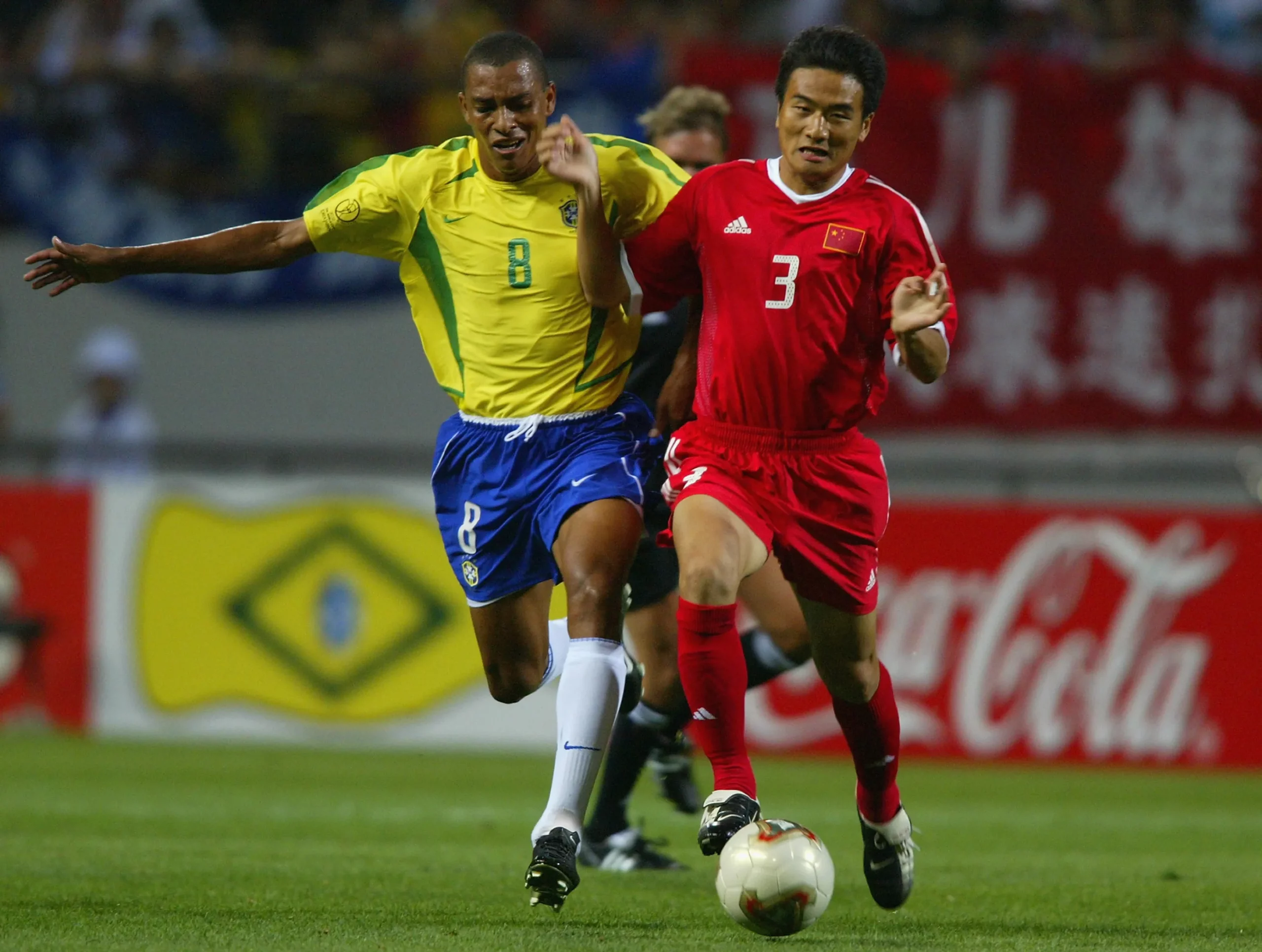 SEOGWIPO – JUNE 8:  Gilberto Silva of Brazil tackles Pu Yang of China during the FIFA World Cup Finals 2002 Group C match played at the Seogwipo-Jeju World Cup Stadium, in Seogwipo, South Korea on June 8, 2002. Brazil won the match 4-0. DIGITAL IMAGE. (Photo by Ben Radford/Getty Images)