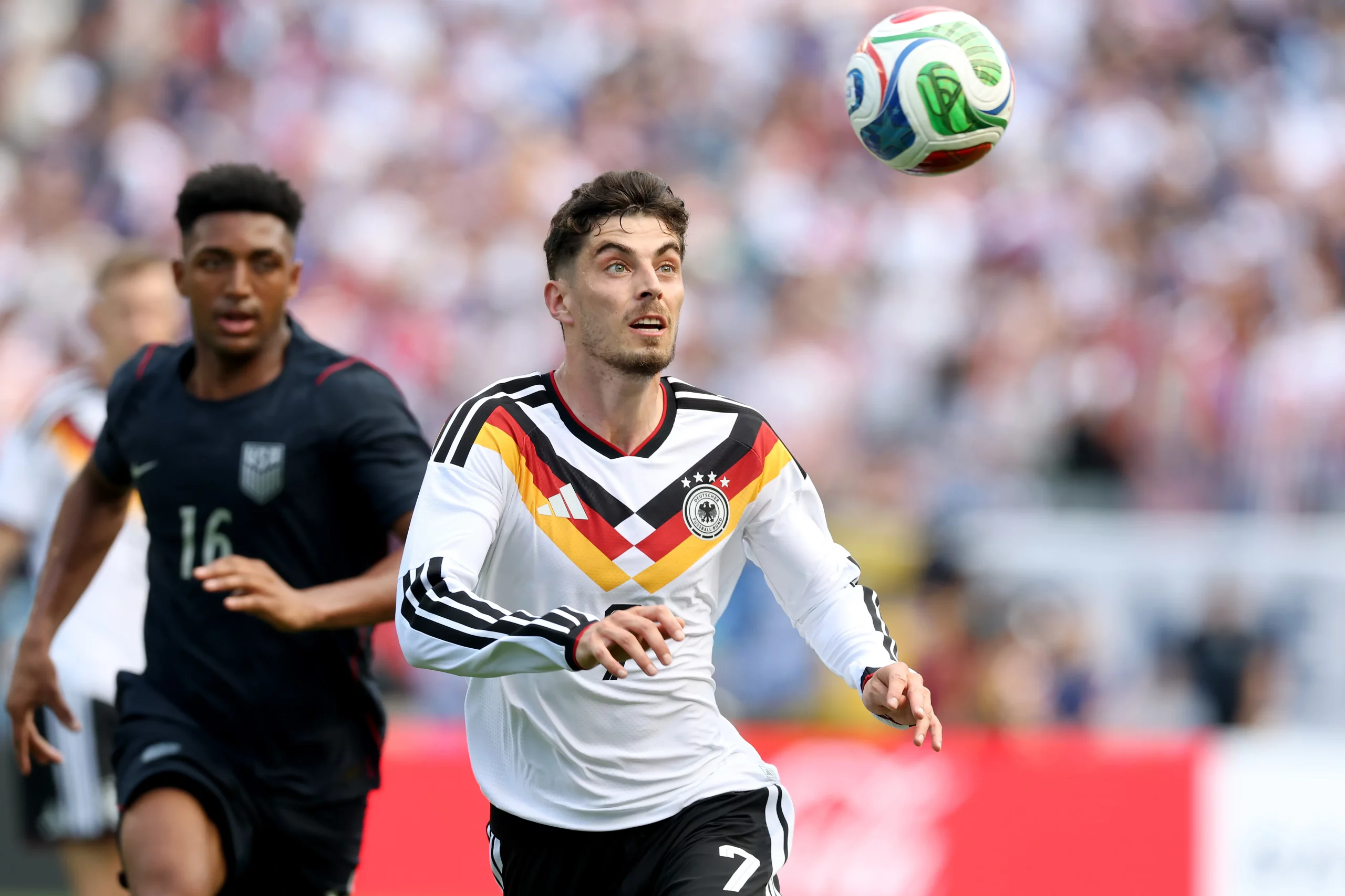 Disputa entre Alex Freeman e Kai Havertz durante o amistoso. Foto: Alexander Hassenstein/Getty Images