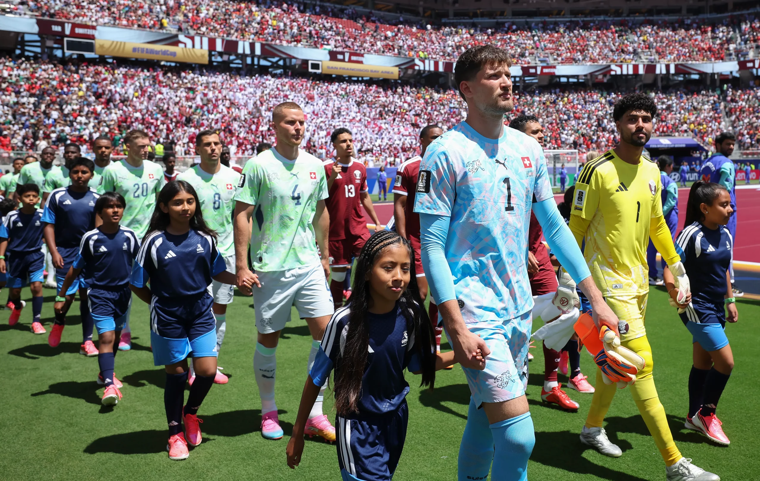 SANTA CLARA, CALIFORNIA – JUNE 13: Gregor Kobel #1 of Switzerland and Mahmoud Abunada #1 of Qatar walk onto the field before the FIFA World Cup 2026 Group B match between Qatar and Switzerland at San Francisco Bay Area Stadium on June 13, 2026 in Santa Clara, California. (Photo by Alex Grimm/Getty Images)