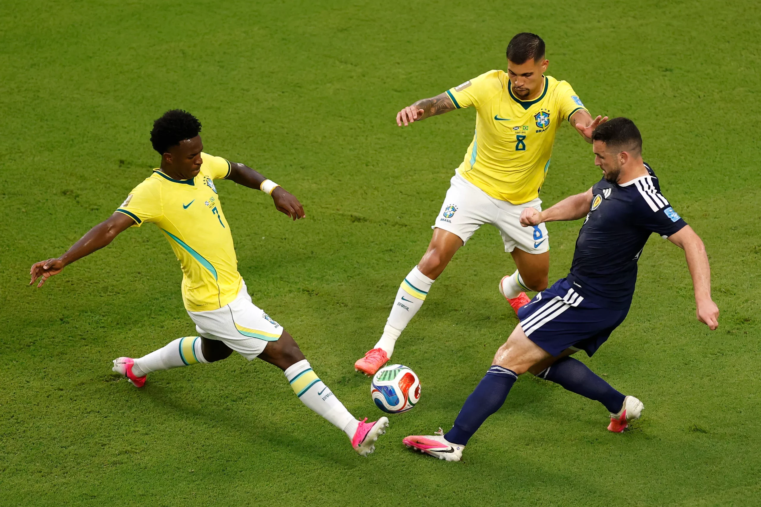 MIAMI GARDENS, FLORIDA – JUNE 24: John McGinn #7 of Scotland competes for the ball against Vinicius Junior #7 and Bruno Guimaraes #8 of Brazil during the FIFA World Cup 2026 Group C match between Scotland and Brazil at Miami Stadium on June 24, 2026 in Miami Gardens, Florida. (Photo by Michael Reaves/Getty Images)
