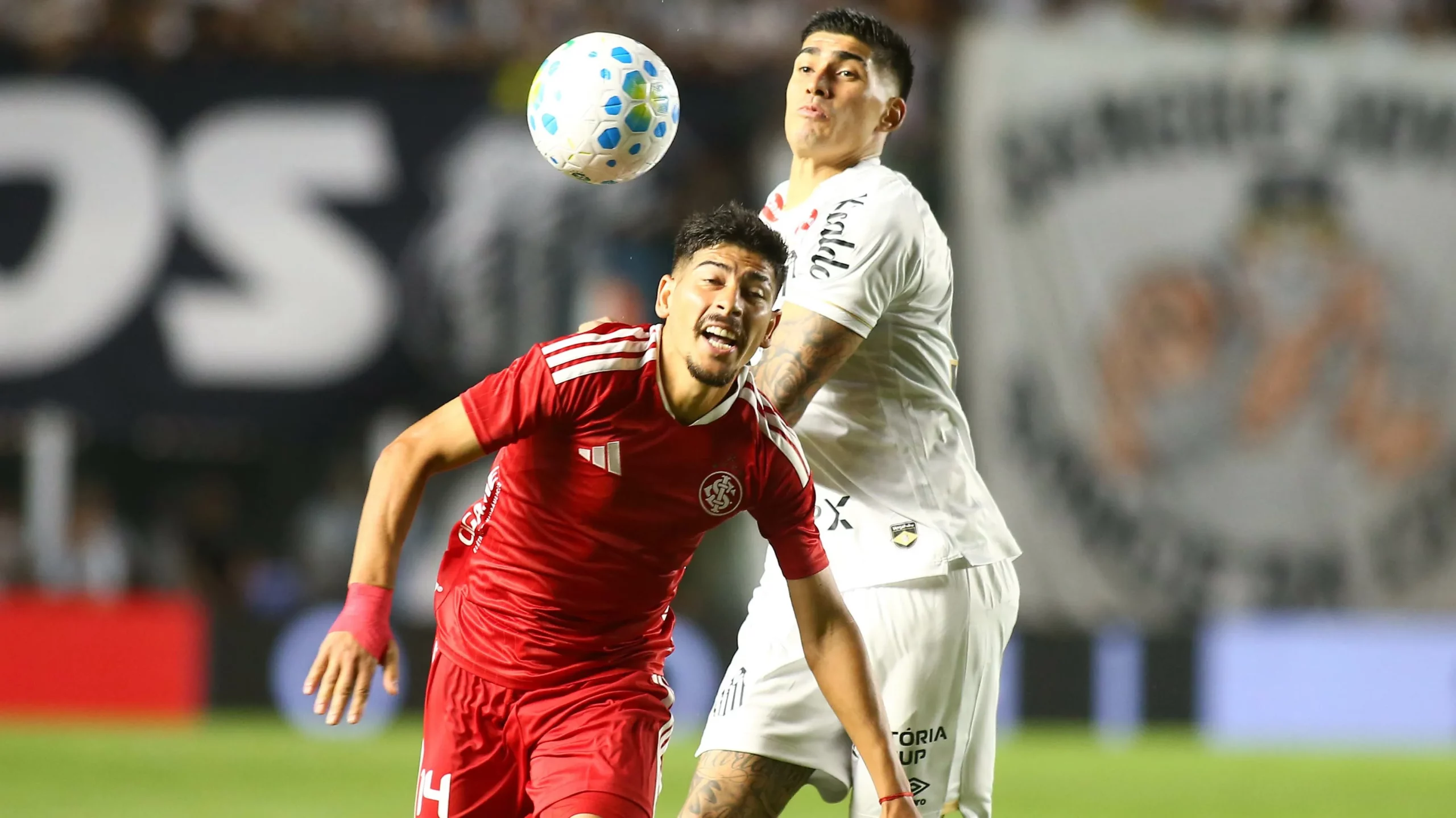 Adonis Frias jogador do Santos disputa lance com Alan Rodriguez jogador do Internacional durante partida no estadio Vila Belmiro pelo campeonato Brasileiro A 2026. Foto: Mauricio De Souza/AGIF