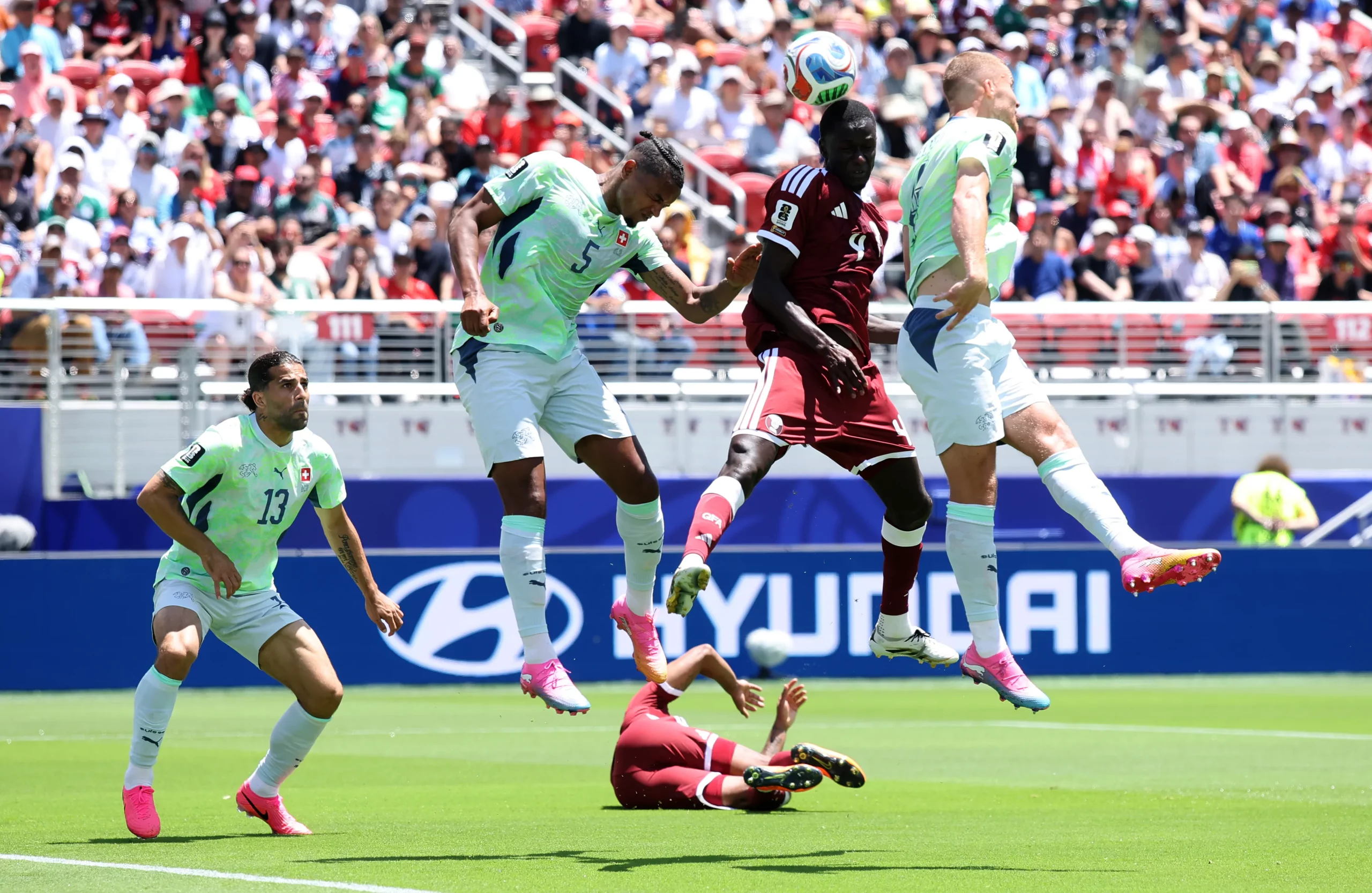 SANTA CLARA, CALIFORNIA – JUNE 13: Issa Laye #4 of Qatar heads the ball against Manuel Akanji #5 and Nico Elvedi #4 of Switzerland during the FIFA World Cup 2026 Group B match between Qatar and Switzerland at San Francisco Bay Area Stadium on June 13, 2026 in Santa Clara, California. (Photo by Alex Grimm/Getty Images)